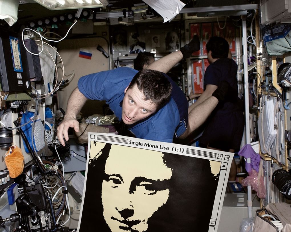 Итальянский астронавт Роберто Витори с картиной «Single Mona Lisa 1:1» в невесомости на борту Международной космической станции. Апрель 2005 года